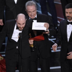 Jordan Horowitz, producer of "La La Land," shows the envelope revealing "Moonlight" as the true winner of best picture at the Oscars on Sunday, Feb. 26, 2017, at the Dolby Theatre in Los Angeles. Presenter Warren Beatty and host Jimmy Kimmel look on from right. (Photo by Chris Pizzello/Invision/ANSA/AP) [CopyrightNotice: 2017 Invision]