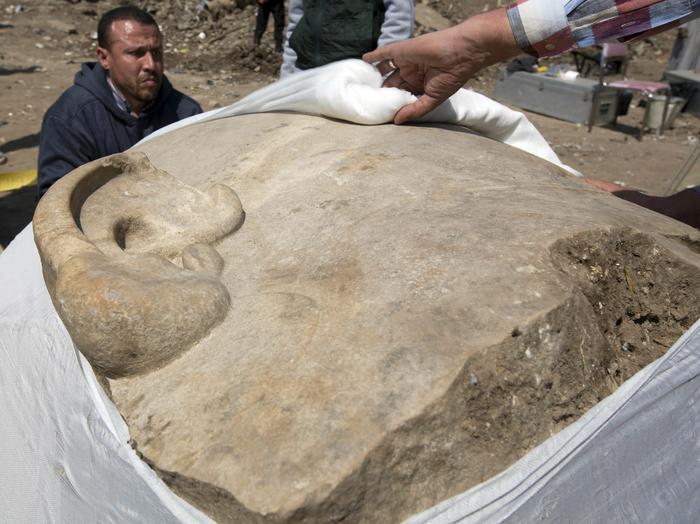 Antiquities workers cover the head of a massive statue, that may be of pharaoh Ramses II, one of the country's most famous ancient rulers, which was found in groundwater in a Cairo slum, Egypt, Monday, March 13, 2017. (ANSA/AP Photo/Amr Nabil) [CopyrightNotice: Amr Nabil]