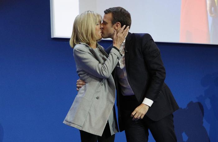 epaselect epa05924528 French presidential election candidate for the 'En Marche!' (Onwards!) political movement, Emmanuel Macron (R) kisses his wife his wife Brigitte Trogneux (L) after the first round of the French presidential elections in Paris, France, 23 April 2017. Media reports that polling agencies projections place Macron and far-right Front National (FN) party candidate Marine Le-Pen in the lead positions for the vote. France will hold the second round of the presidential elections on 07 May 2017.  EPA/YOAN VALAT