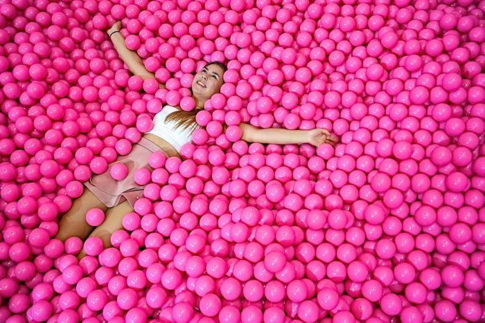 epa07948878 A girl enjoys a ball bath as she is being photographed at the made-for-Instagram museum 'Cali Dreams' in Dusseldorf, Germany, 25 October 2019. No artworks are shown in this museum, rather each visitor himself becomes an artwork by staging himself in front of one of the 25 sceneries. Cali Dreams is initially open for three months. After this test phase, however, the museum is planned as a long-term project.  EPA/SASCHA STEINBACH