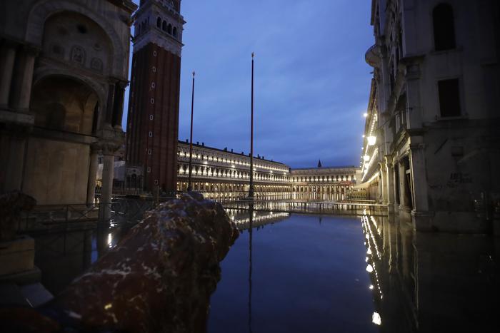 St. Mark square is reflected in flood water at dawn in Venice, Italy, Sunday, Nov. 17, 2019. Venetians are bracing for the prospect of another exceptional tide in a season that is setting new records. Officials are forecasting a 1.6 meter (5 feet, 2 inches) surge Sunday. That comes after Tuesday's 1.87 meter flood, the worst in 53 years, followed by high tide of 1.54 meters on Friday. (ANSA/AP Photo/Luca Bruno) [CopyrightNotice: Copyright 2019 The Associated Press. All rights reserved.]