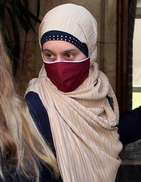 Italian aid worker, Silvia Romano, wearing a Somali garb and face mask, covers her face leaving a beauty center, at the end of her compulsory quarantine in Milan, Italy, 25 May 2020. The beauty centeris the first destination chosen by Silvia Romano at the end of the 14-day quarantine, taken when she returned home to Milan on 11 May after being kidnapped for a year and a half between Kenya and Somalia. ANSA/MATTEO BAZZI